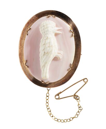 Pink oval shell cameo brooch with kookaburra in a 9ct plain gold setting. Gold chain and pin.