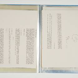 Open blue folder. White page on left has printed text. Right page has printed text and drawing.