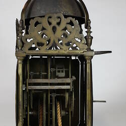 Rectangular metal clock with domed top, side view.