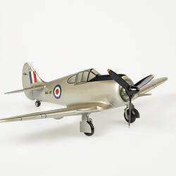 Model aeroplane, silver with a black propeller and wheels.
