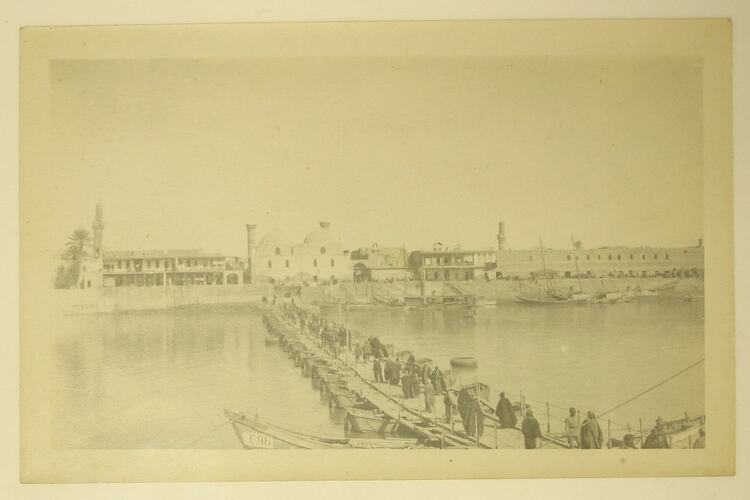 People crossing pontoon bridge over Tigris River towards Baghdad.