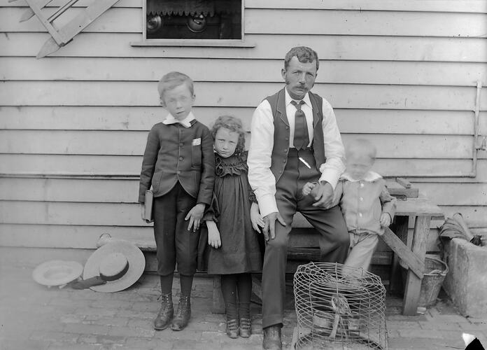 Two Boys, Girl & Man Sitting on Bench, Bird Cage in Front, on Back Verandah, Preston, circa 1902