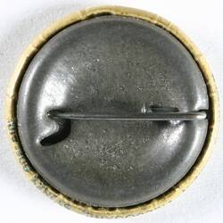 Back of badge showing fastening pin.
