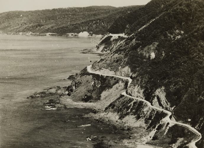 Winding road on cliff face beside the ocean.