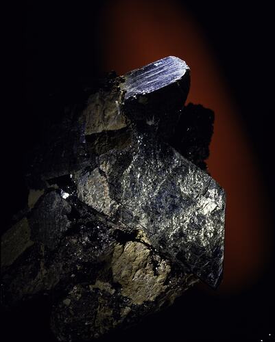 Black crystals on a brown rock.