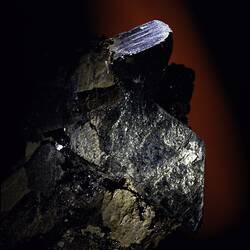 Black crystals on a brown rock.