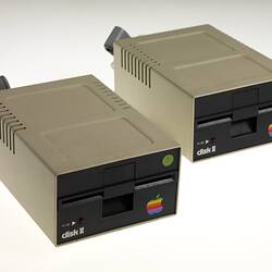 Two beige boxes with black fronts. Both have colourful Apple computer logo.