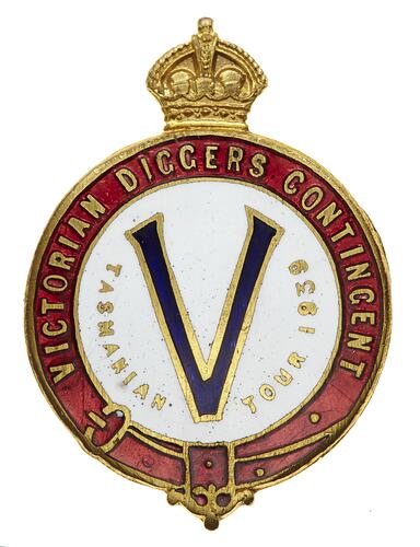 Crowned round enamel badge with "V" on white background with gold text and red border.