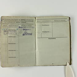 Open book page with printed text, stamp mark on top-right page.