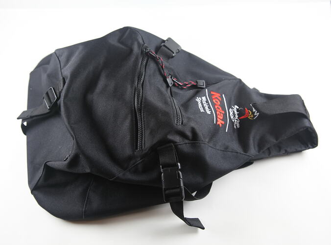 Backpack with zippers and embroidered text.