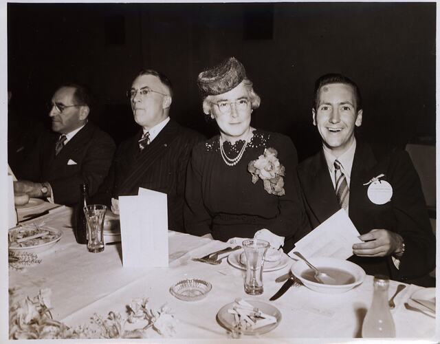 Young man and older woman at dinner table.
