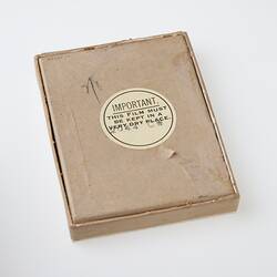 Brown cardboard box with round label.