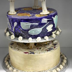 Side of lower two tiers of ceramic wedding cake.