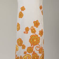 Long sleeveless white cotton dress with orange and yellow floral printed pattern.