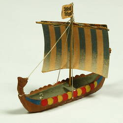 Three quarter view of ship with dragon head and shields.