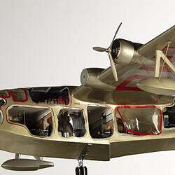 Green-silver model aeroplane on stand. Cutaways on side show interior. Close up of front section.
