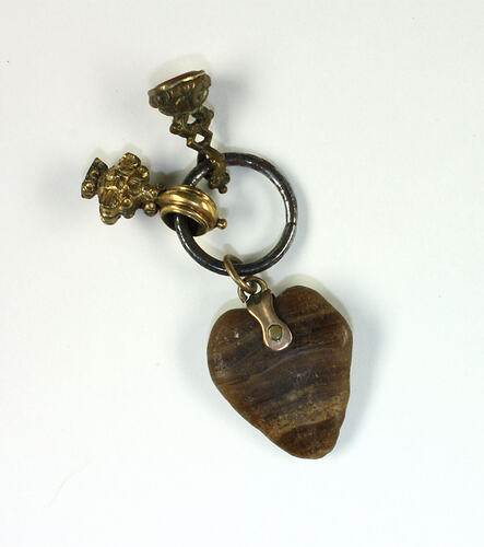 Heart-shaped charm with two smaller charms in velvet lined box.