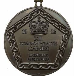 Medal has pentagonal border framing raised crown with text below.