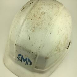 Used, scuffed white safety helmet. Three quarter view.