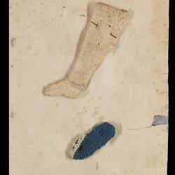 Page 22 of an unbound book containing two sewing samples. White stocking and a blue sock.
