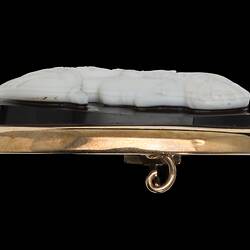Profile of oval brooch, white cameo of female facing right with black background set in gold border.