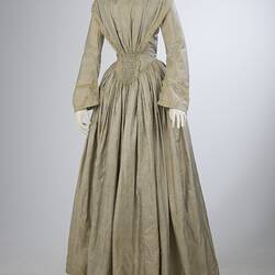 Pale grey striped silk dress with long sleeves and long skirt.