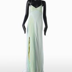 Full length pale green silk evening slip dress. Sleeveless. Flared/fishtail skirt with long slit at right.