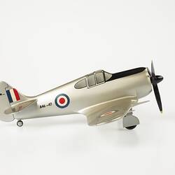 Model aeroplane, silver with a black propeller and wheels. Right profile.