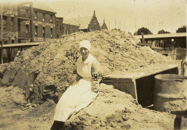Digital Photograph - Trainee Nurse Sitting on Pile of Sand at Alfred Hospital Building Site, Prahran, circa 1927