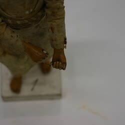 Detail of the hands of a clay figure wearing rope belt.