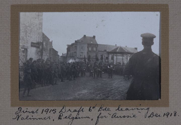 Large group of serviceman lining street sides, with service men holding instruments in centre.