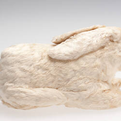 White plush rabbit toy, side view.