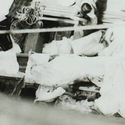View from above of a lifeboat with passengers covered in sheets and bandages.