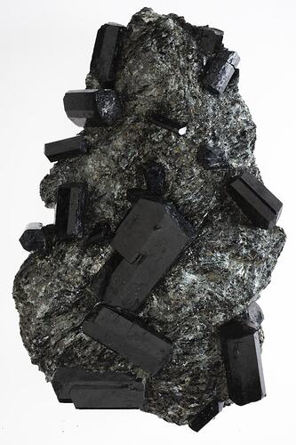 Blocky black crystal rods on a shiny black rock.