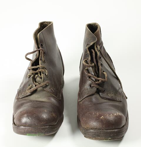Pair of brown leather lace-up boots, with leather soles and brown laces, front view.