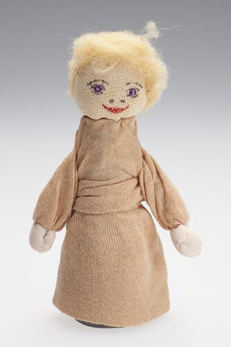 Cone-shaped cotton doll with yellow hair and brown body.