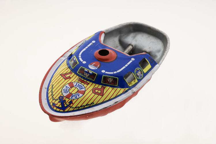 Brightly coloured little metal speedboat toy.