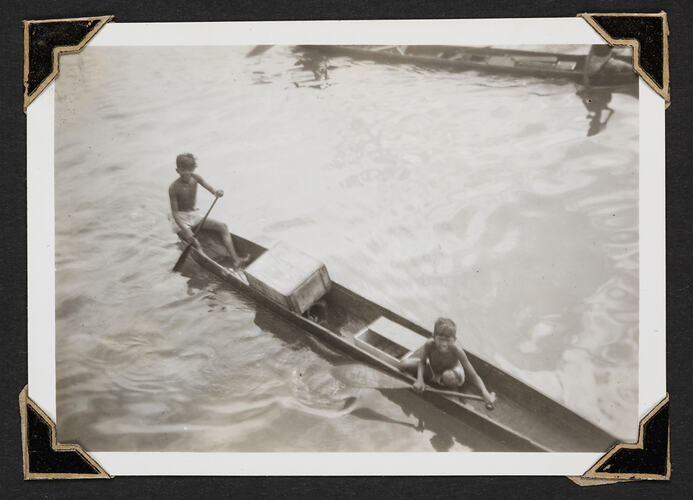 Two children rowing canoe.