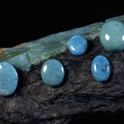 Polished turquoise specimens on a raw turquoise specimen.