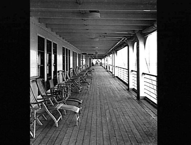 Ship promenade deck. Deck chairs at left.