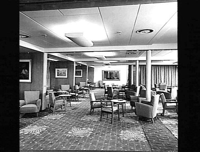 Ship interior. Room with upholstered chairs and armchairs around tables. Lounge area.