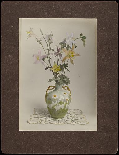 Still life of pink, yellow and white flowers in floral vase.