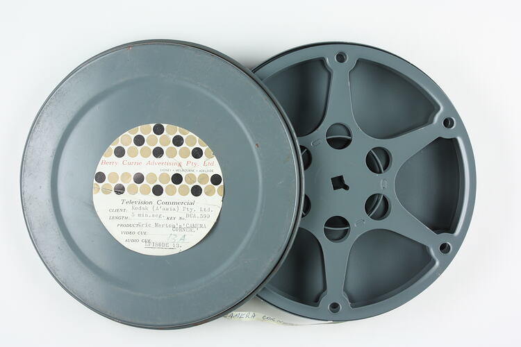 Open metal canister with empty film reel inside.
