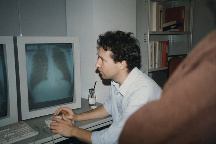 Man on computer with x-ray on screen.