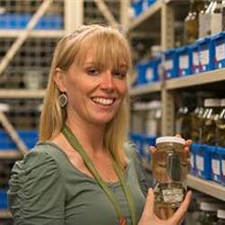 Dr Katie Smith holding specimen jar in wet collection.