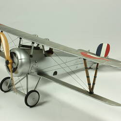 Model biplane with French national colours on tail.