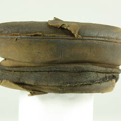 Front view of old battered nightsoil collector's khaki flat top cap