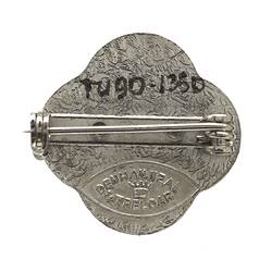 Back of metal badge with pin.