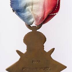 Back of bronze four point star medal 'ensigned' by a crown. Red, white and blue ribbon. Stamped inscription.