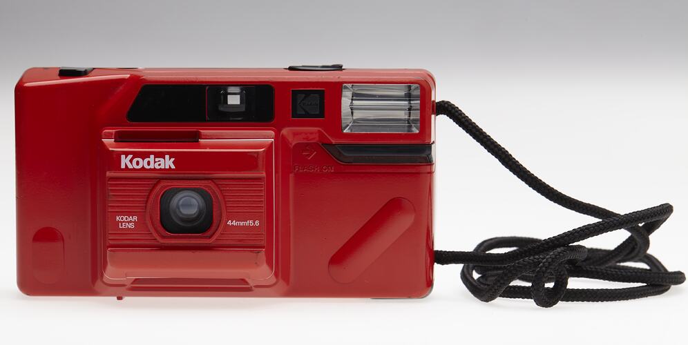 Red plastic camera with black cord strap.